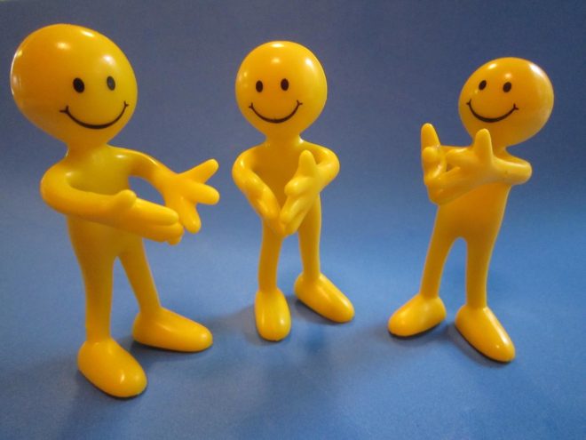 three yellow happy face heads with bodies clapping