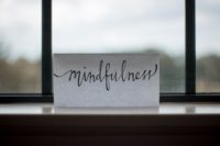 Paper with "mindfulness" written on it resting on a windowsill